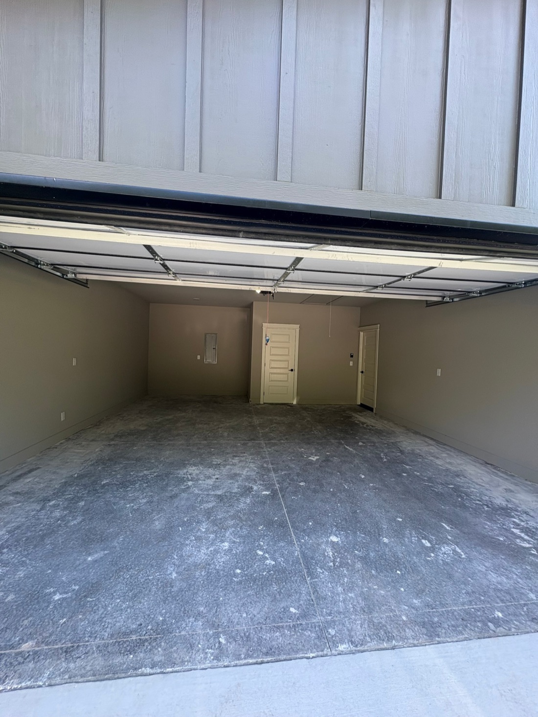 New-construction garage slab before cleaning: dusty, mottled with construction residue
